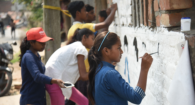 Youth from Prayasam, a GFC alumni partner in India, painting informative murals about COVID-19 prevention.